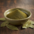 Premium bay leaf powder in ceramic bowl with whole dried bay leaves
